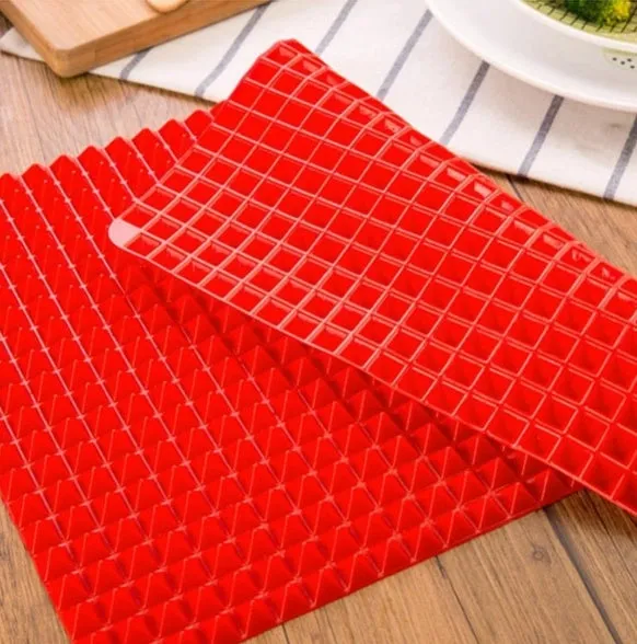 Red silicone pyramid grid cooking mat on a kitchen countertop.