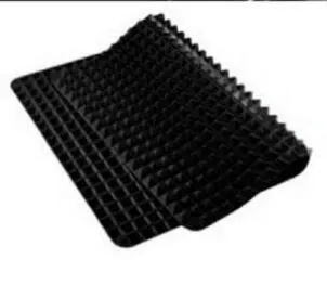 Red silicone pyramid grid cooking mat on a kitchen countertop.