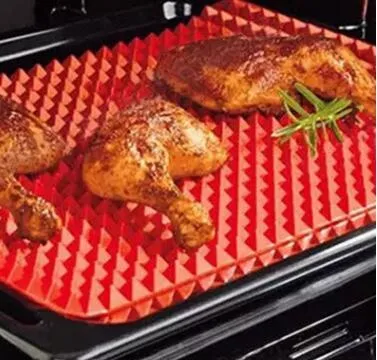 Red silicone pyramid grid cooking mat on a kitchen countertop.