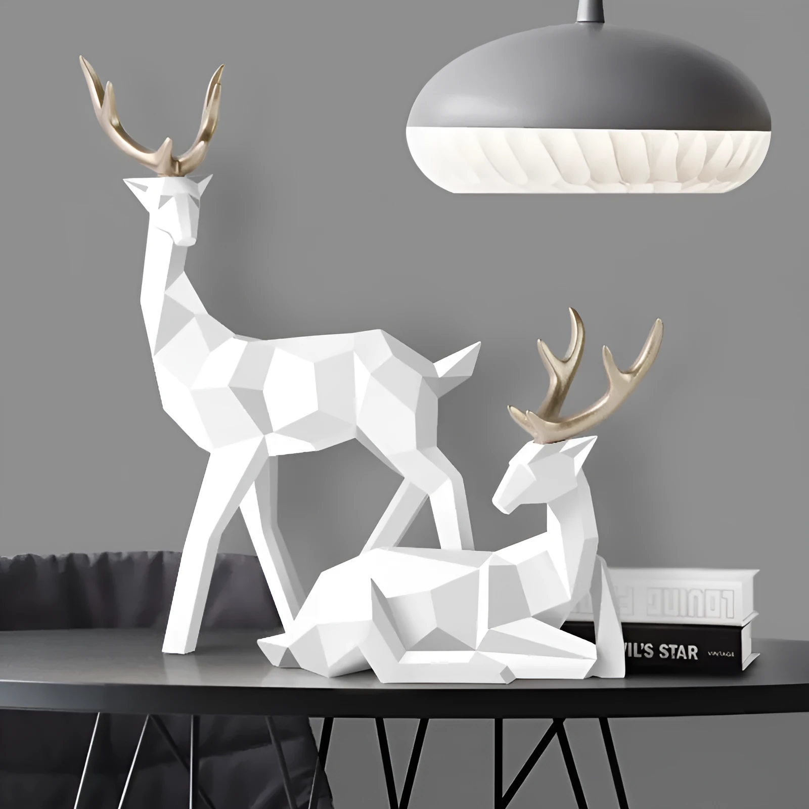 Set of three modern resin deer statues in graduated sizes on a shelf