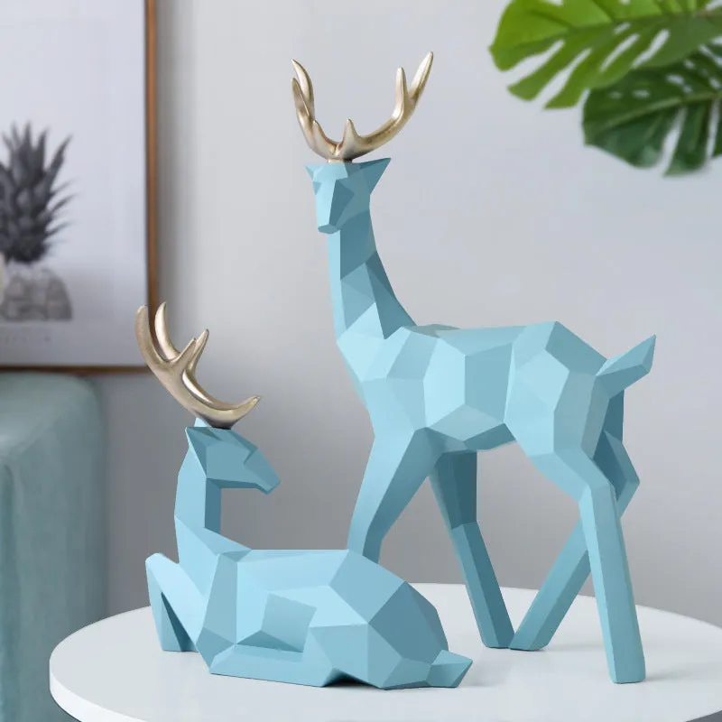 Set of three modern resin deer statues in graduated sizes on a shelf
