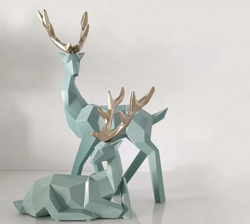 Set of three modern resin deer statues in graduated sizes on a shelf