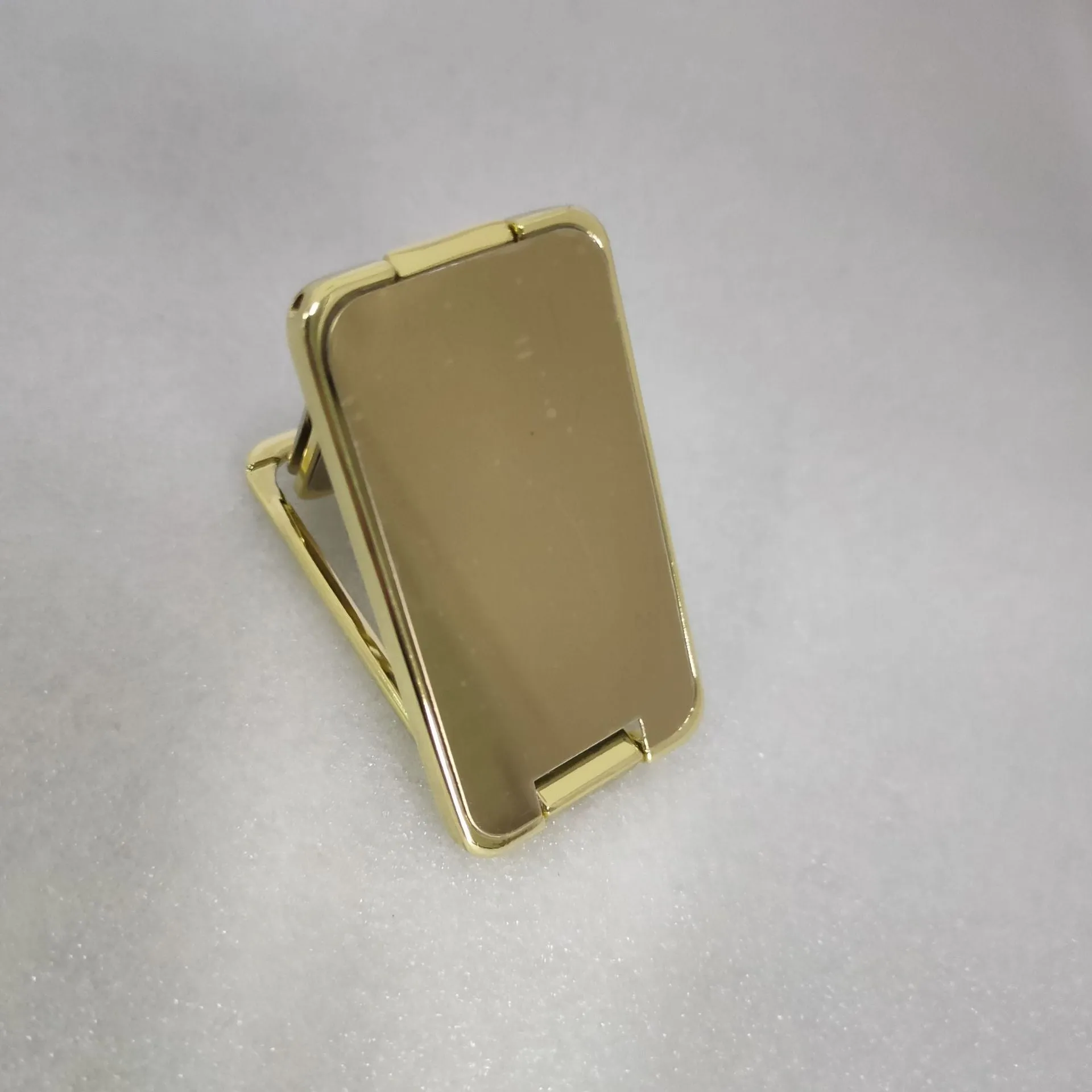 Foldable mobile phone holder with retractable ring buckle in zinc alloy, showing adjustable angle for devices