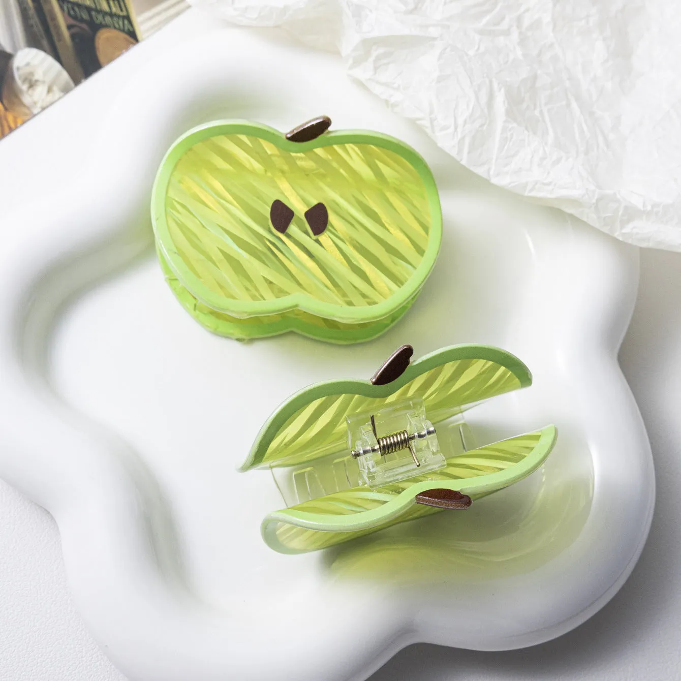 Green apple-shaped claw clip with polished PVC finish, 7.5cm long, on a plain background
