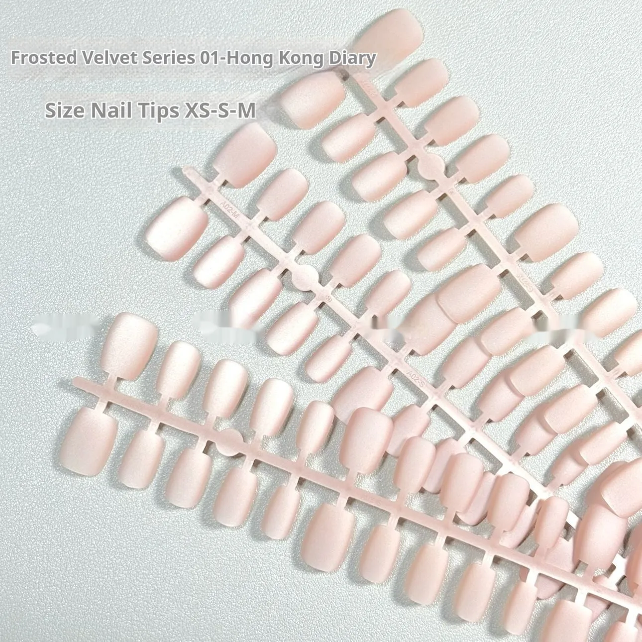 Set of false nails with frosted velvet finish and Cat's Eye designs in short ladder sizes XS, S, and M.