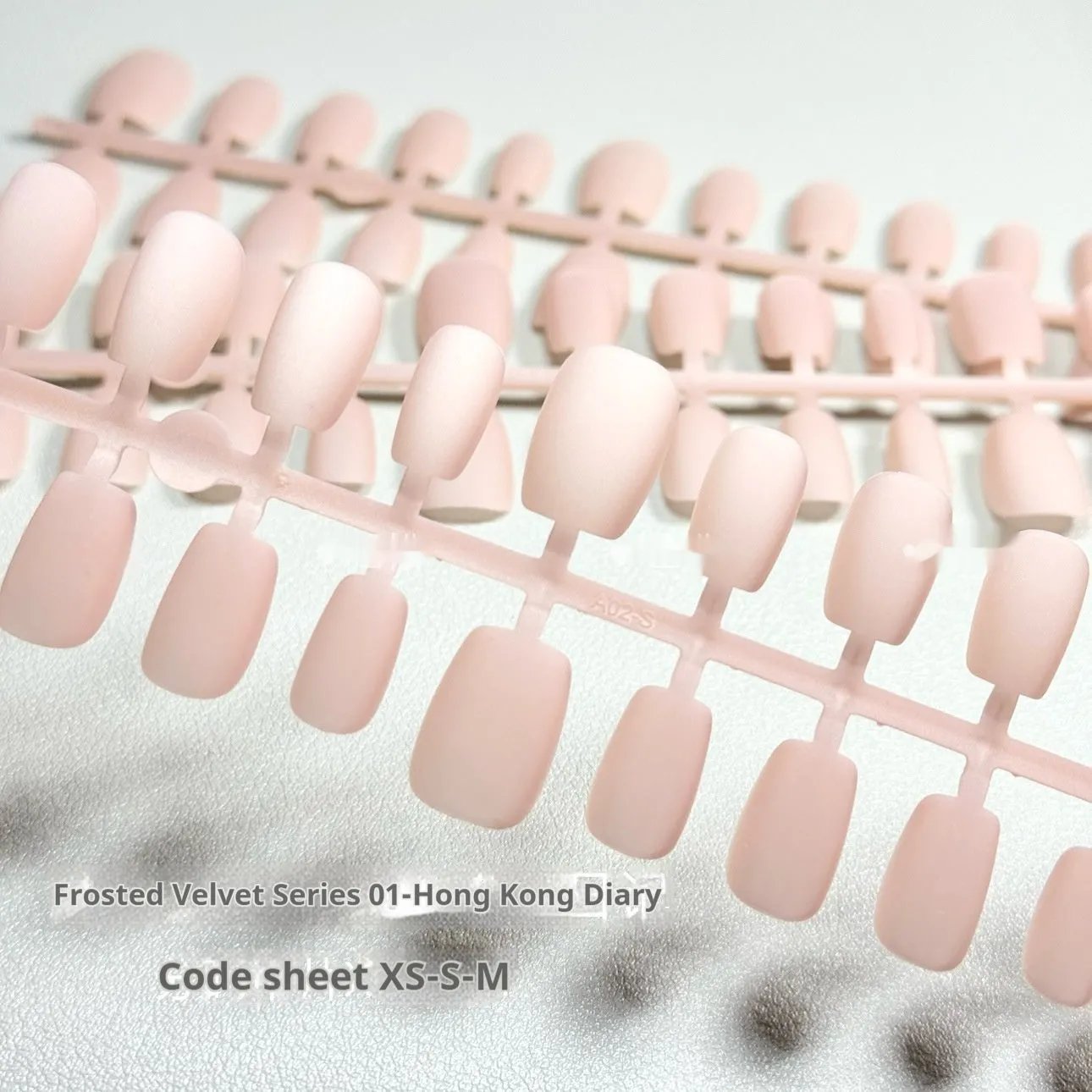 Set of false nails with frosted velvet finish and Cat's Eye designs in short ladder sizes XS, S, and M.