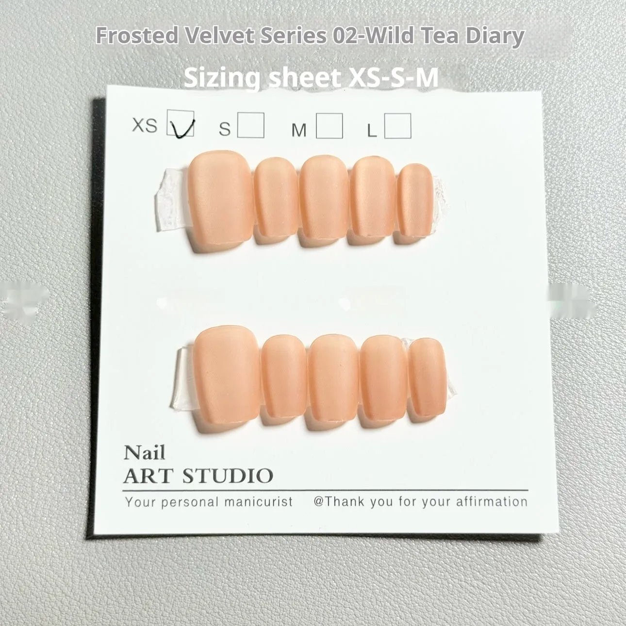 Frosted velvet Cat's Eye Aurora artificial nail art set in short ladder sizes on a display hand.