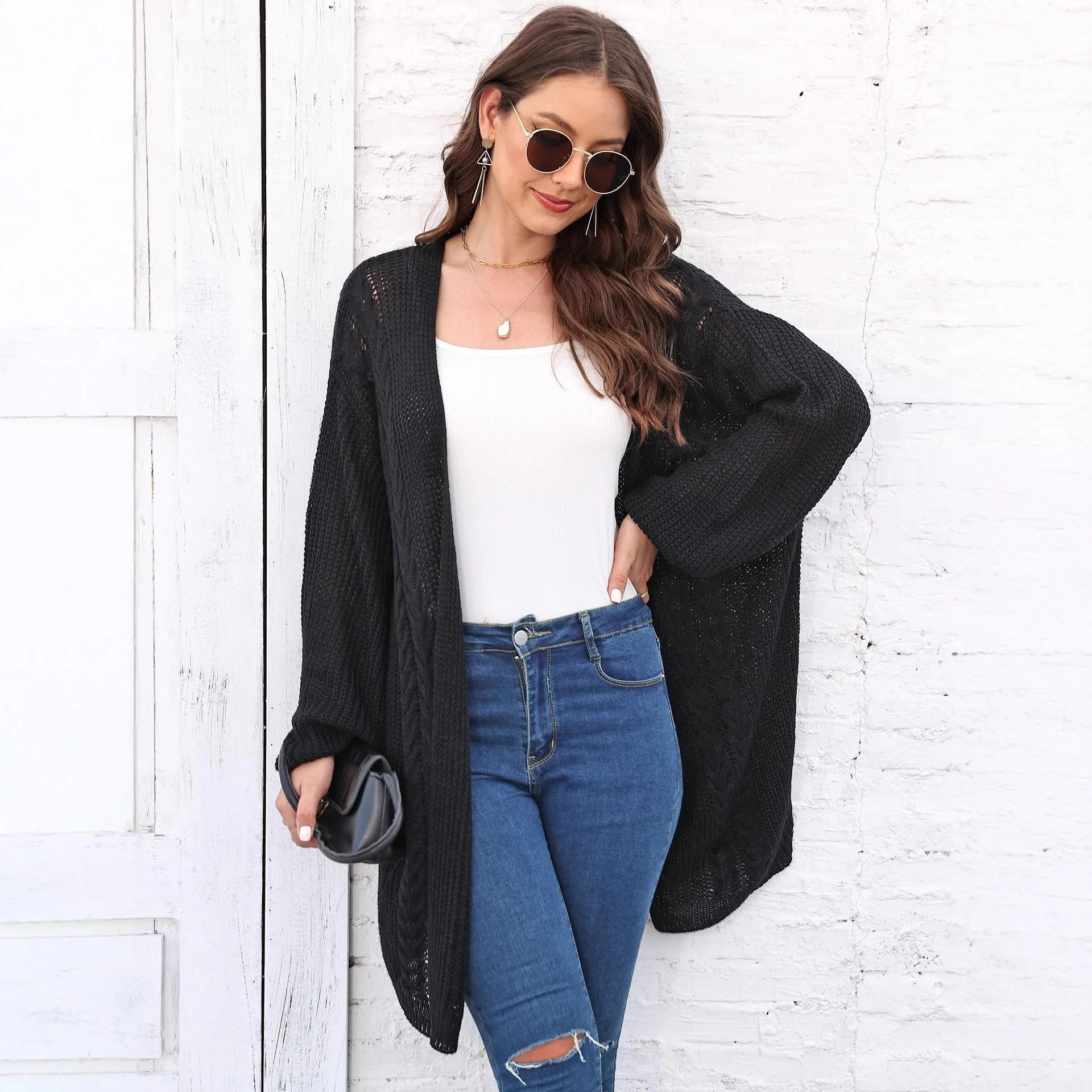 Women's loose acrylic sweater coat in a solid colour, shown in a casual style.