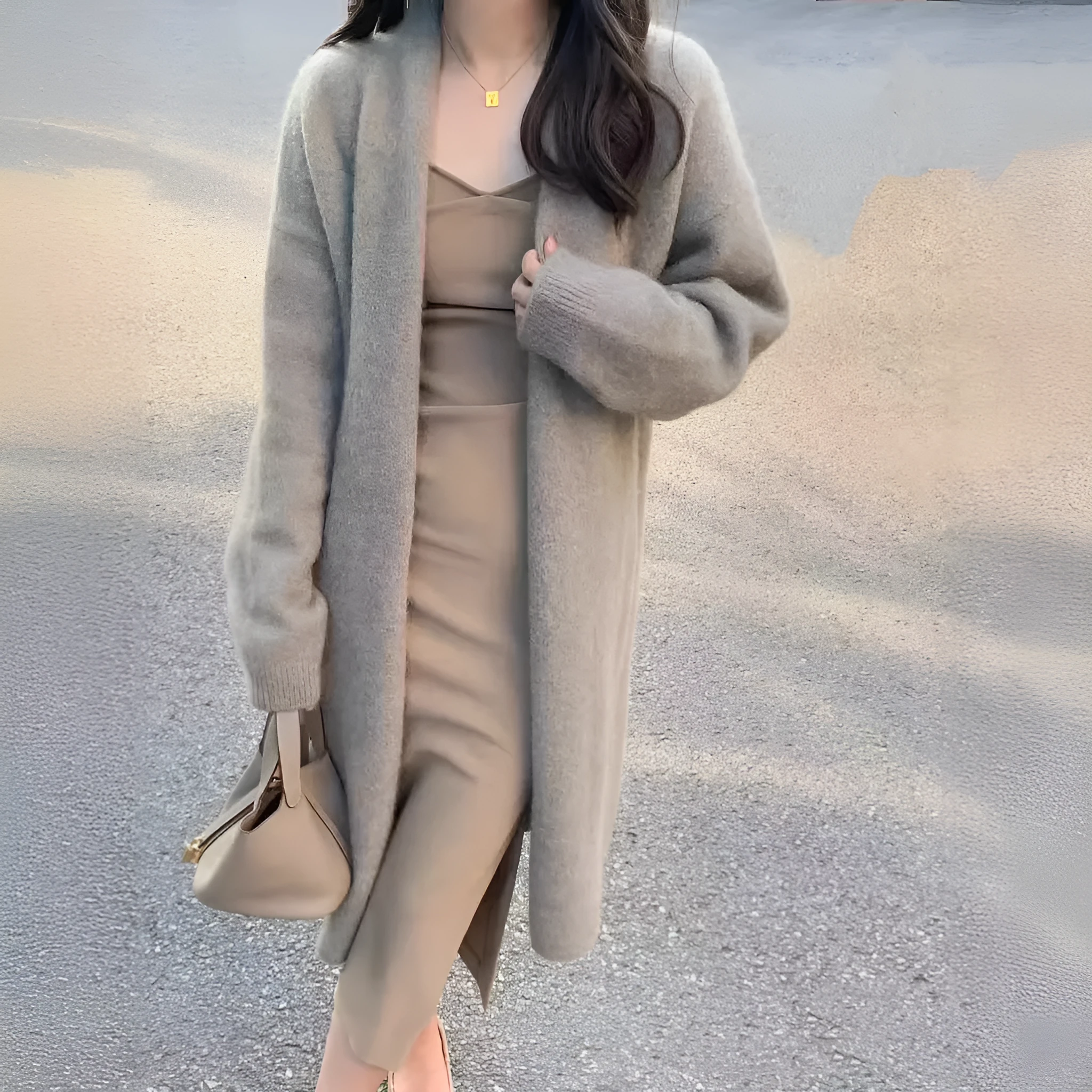 A woman's loose-fit knitted cardigan in a khaki colour with a V-neck and long sleeves, laid flat.