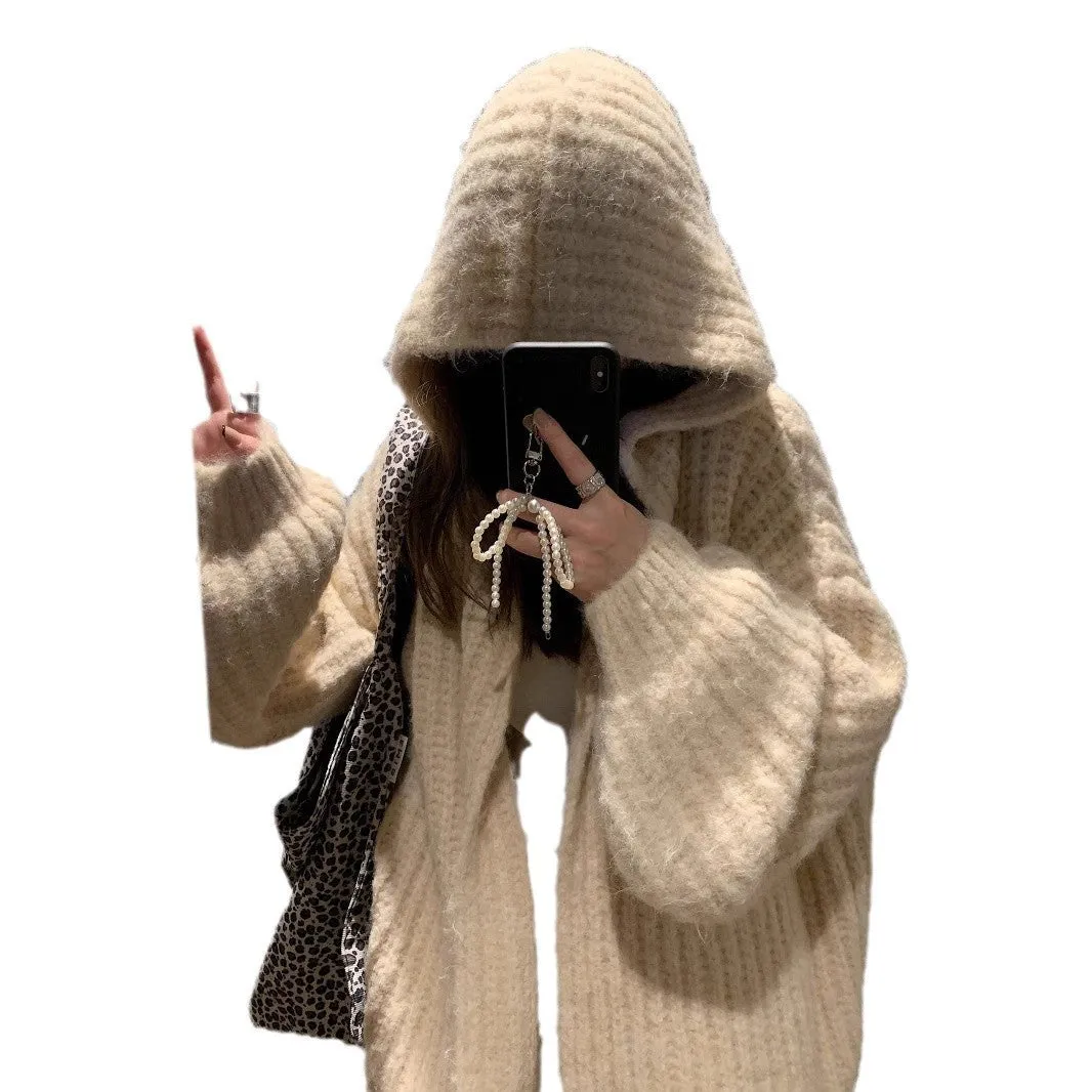 A woman wearing a thick, loose-fit, dark grey hooded sweater cardigan with a retro design.