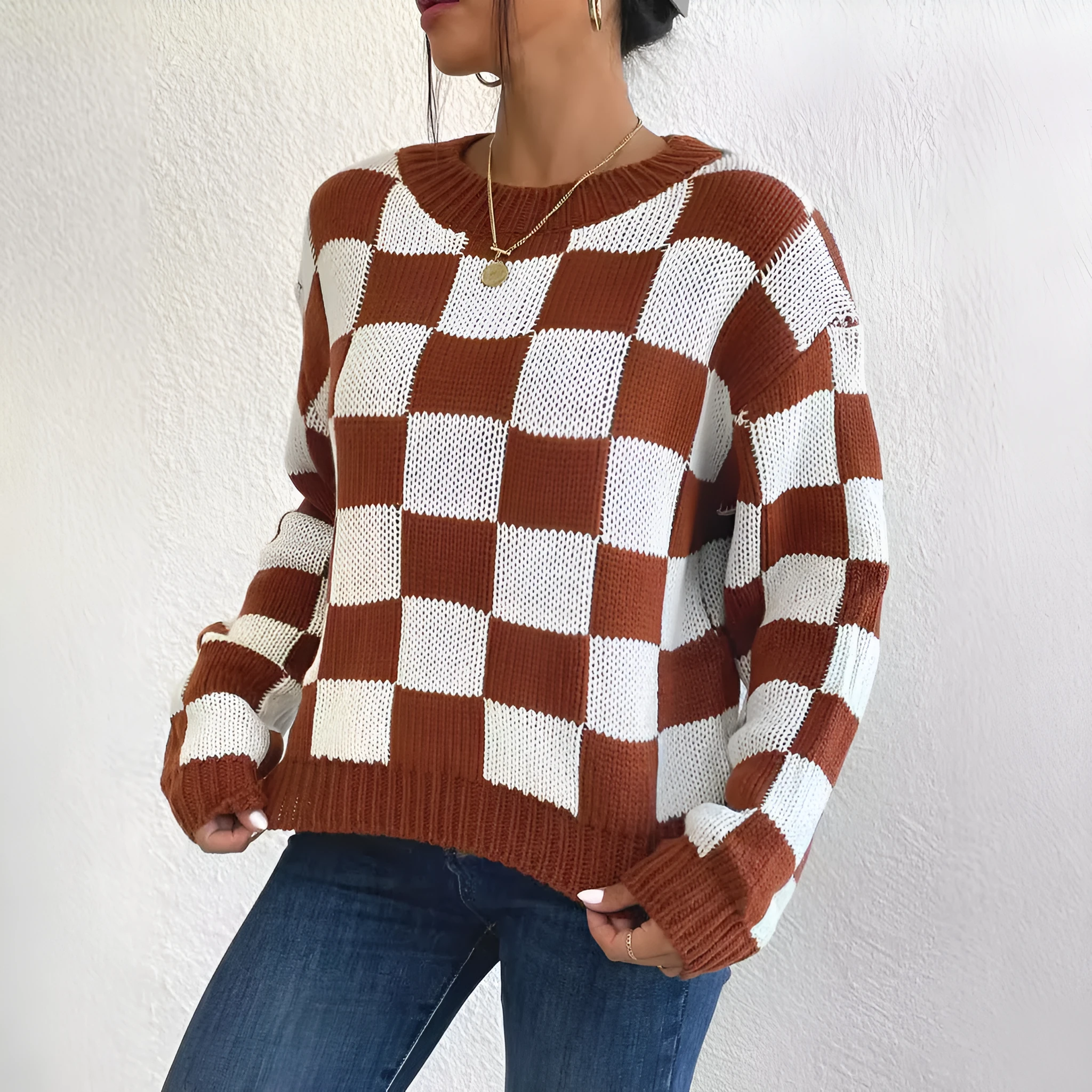 Dark brown plaid pattern long sleeve pullover sweater on a hanger.