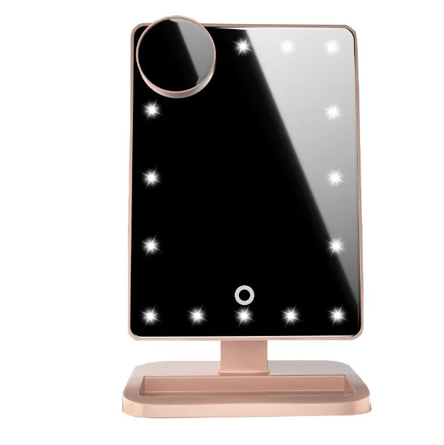 Pink touch screen LED makeup mirror with Bluetooth speaker and magnifying mirror on a table.