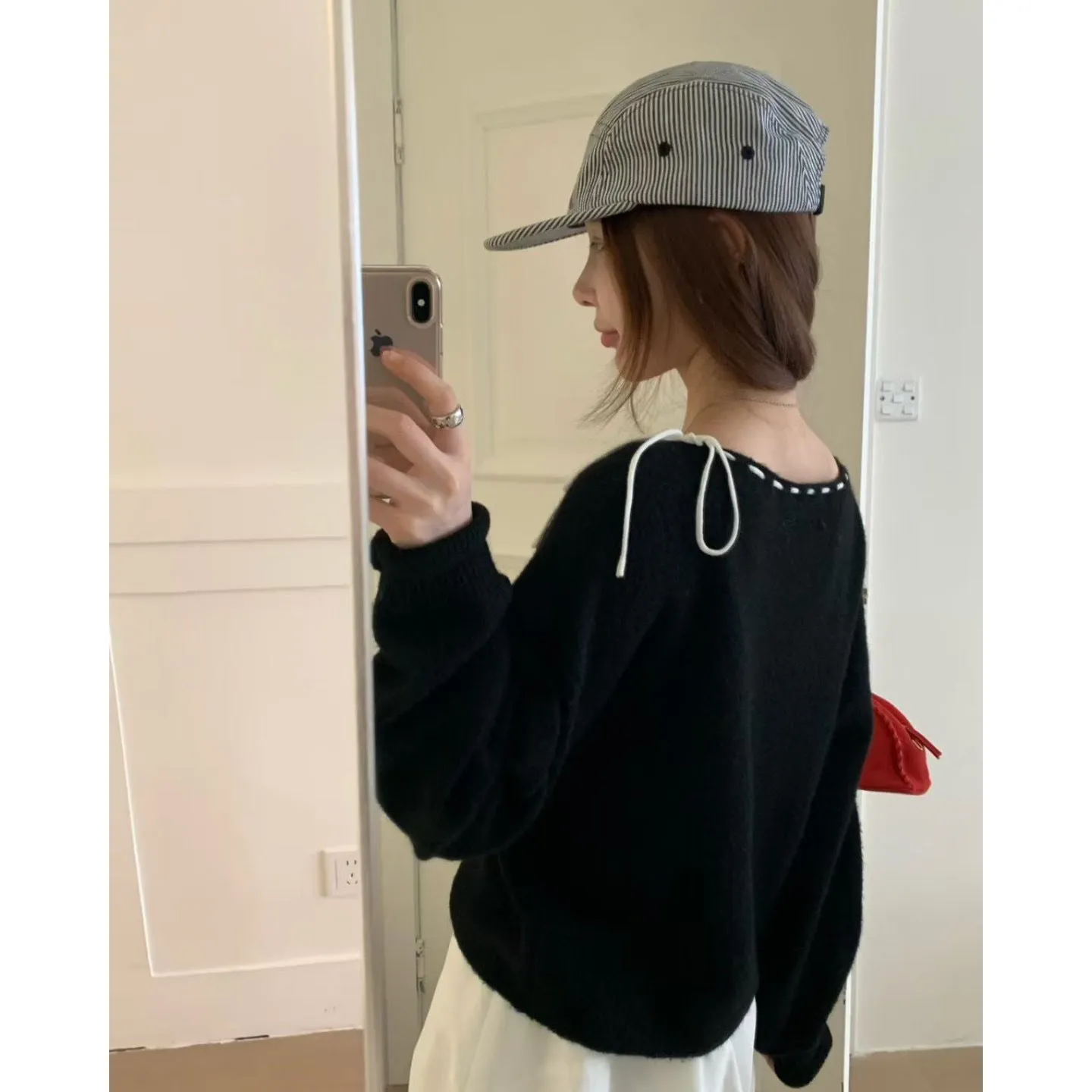 Grey and black versions of a women's loose-fitting pullover jumper made from soft knit fabric.