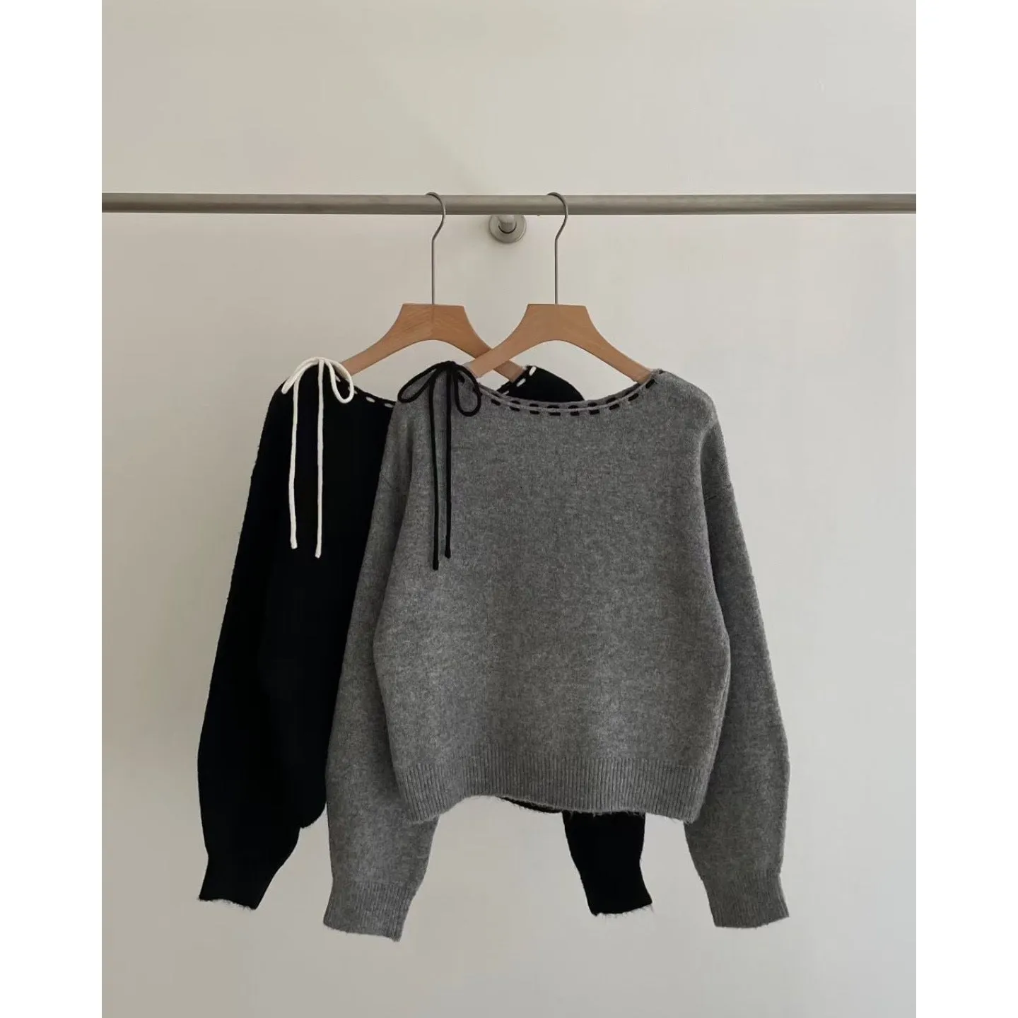 Grey and black versions of a women's loose-fitting pullover jumper made from soft knit fabric.