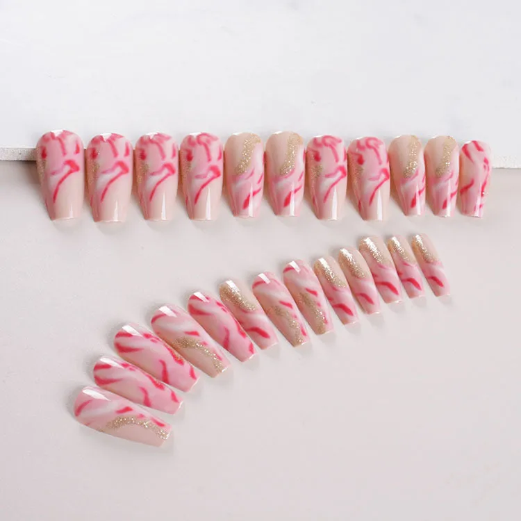 Set of pink press-on artificial nails with rose pattern, shown next to a bottle of nail glue.