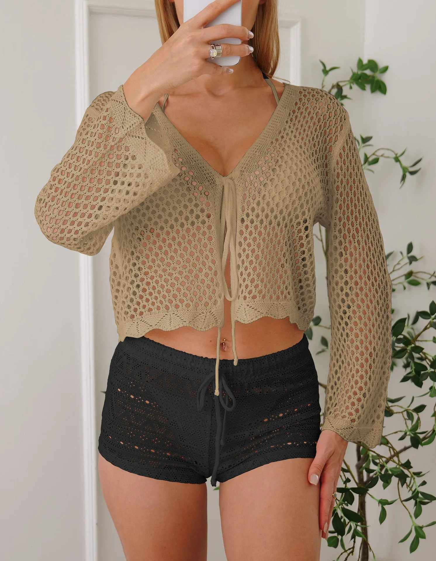 Short apricot hollow woven cardigan blouse with bell sleeves on a hanger.