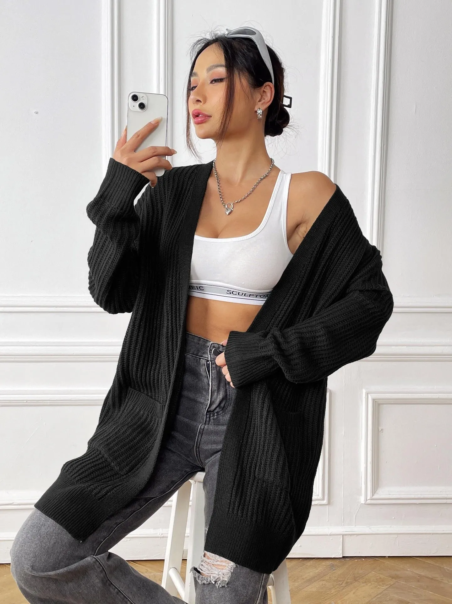 Women's loose fit acrylic cardigan with double pockets in dark green colour showing mid-length design