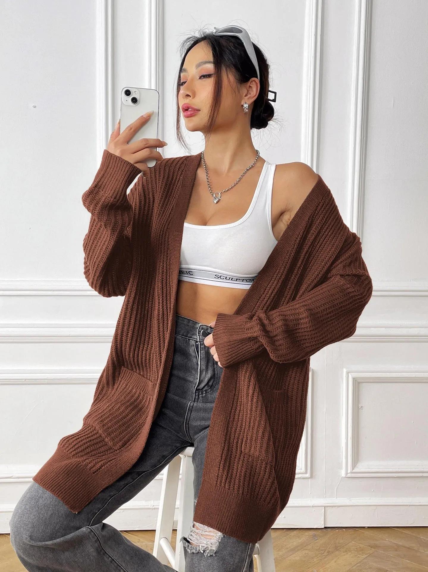 Women's loose fit acrylic cardigan with double pockets in dark green colour showing mid-length design