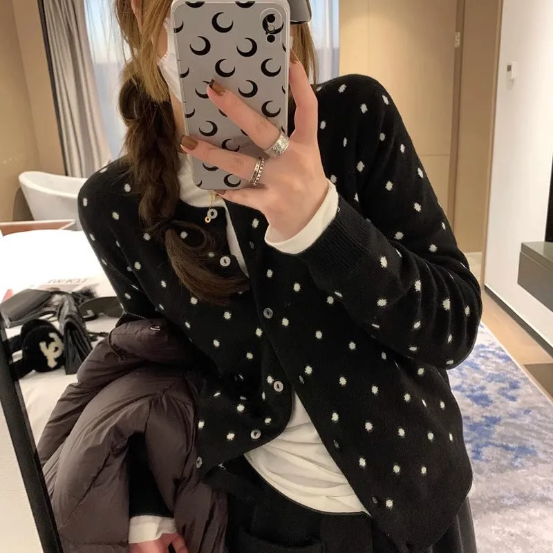 Women's grey loose-fit knitted cardigan with a crocheted flower on the front.