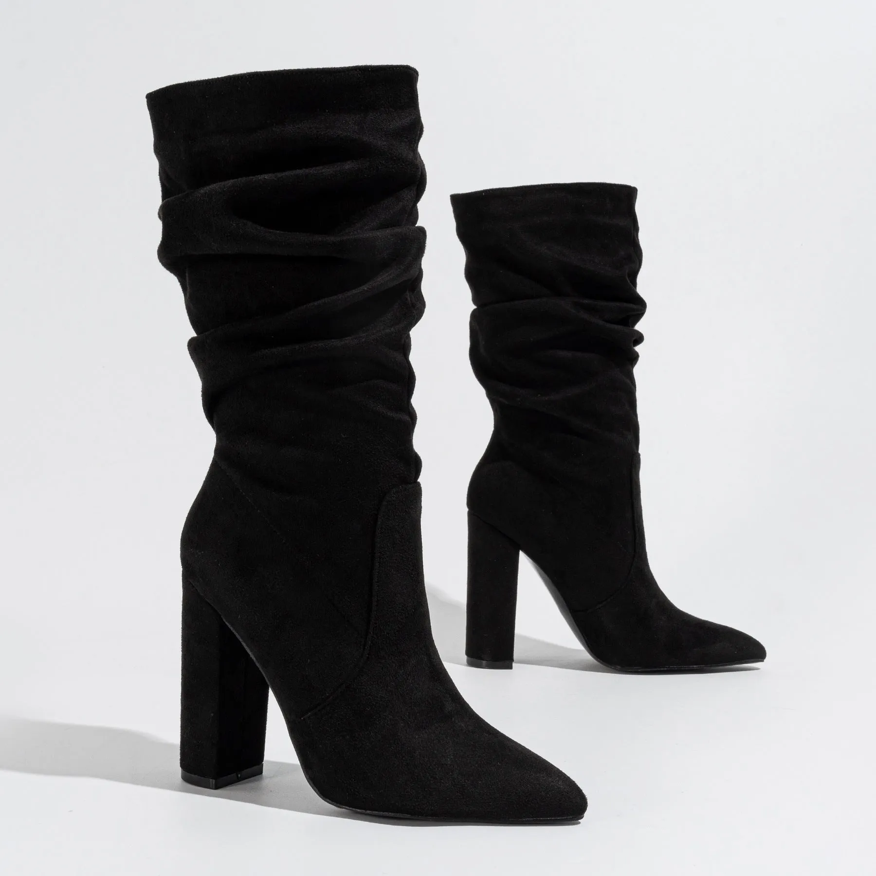 Women's black suede pointed-toe boots with a chunky high heel and pile-style ankle cuff.