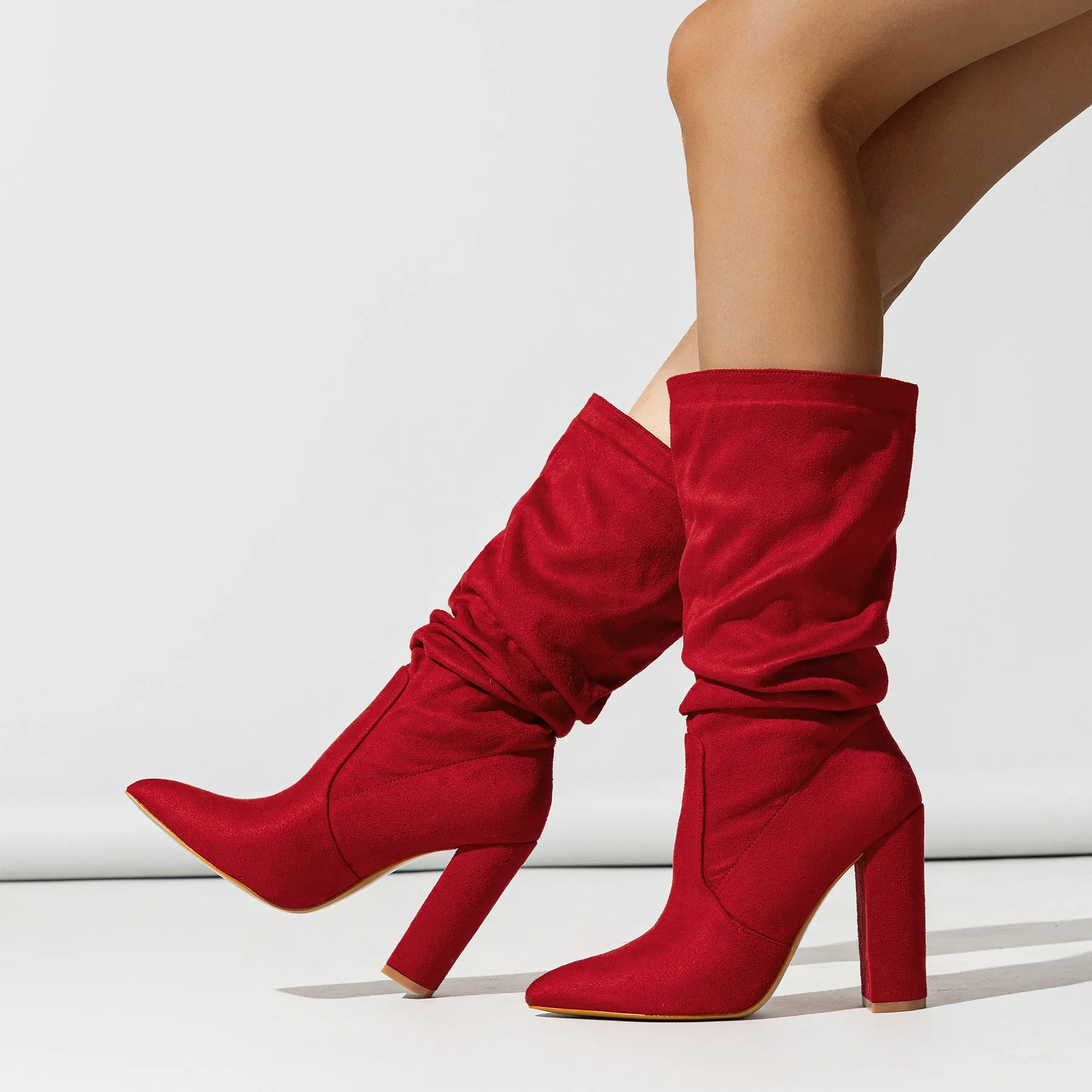 Women's black suede pointed-toe boots with a chunky high heel and pile-style ankle cuff.