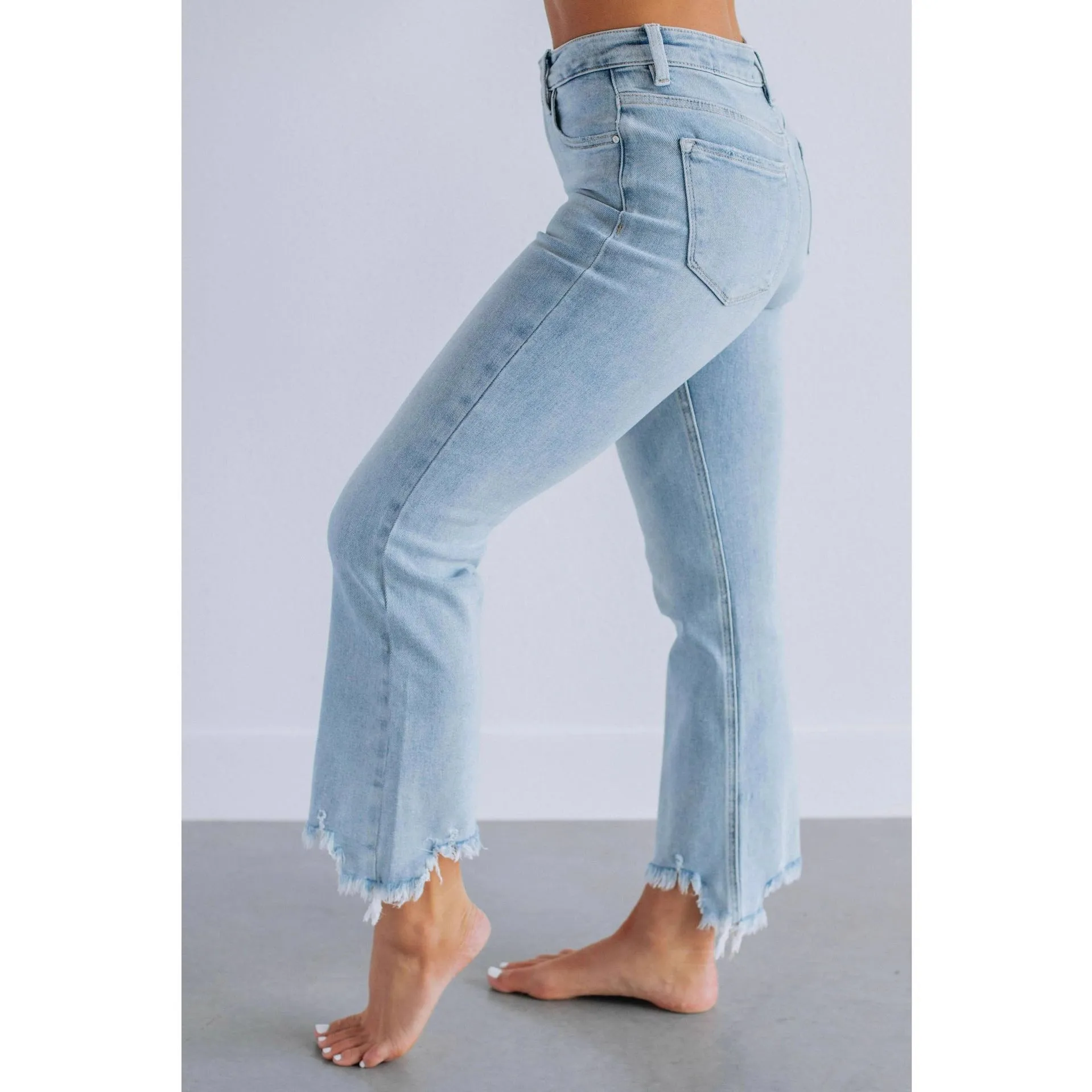 Women's solid colour denim jeans in dark blue showing hand-worn texture and casual fit.