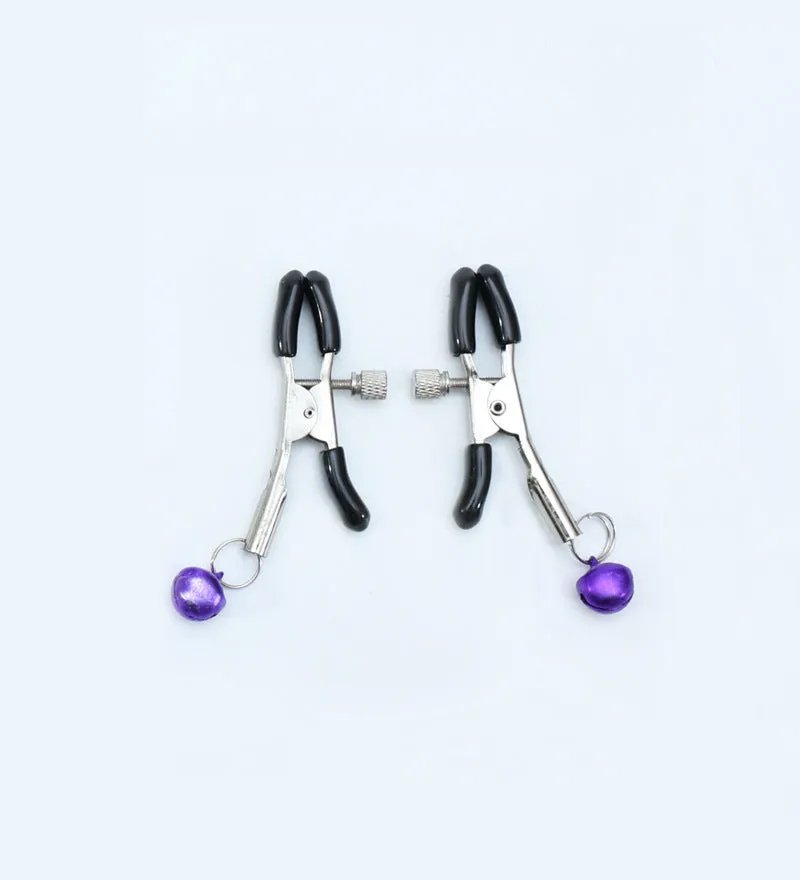 Red bell nipple clamp pair with chain attachment on a dark background