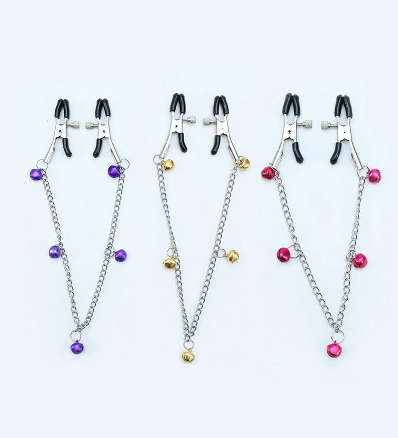 Red bell nipple clamp pair with chain attachment on a dark background