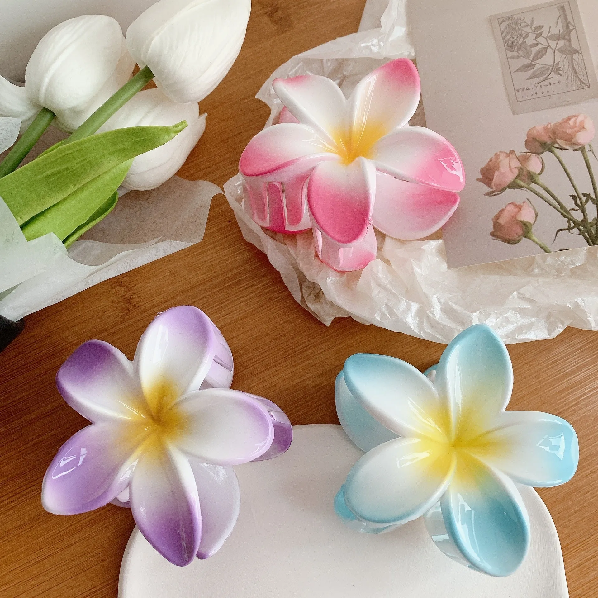 Muweordy plumeria hair claw clip in blue, a decorative flower hair accessory made from plastic and resin.