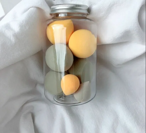 Set of 7 makeup sponge eggs in various colours inside transparent jar with multiple cut shapes