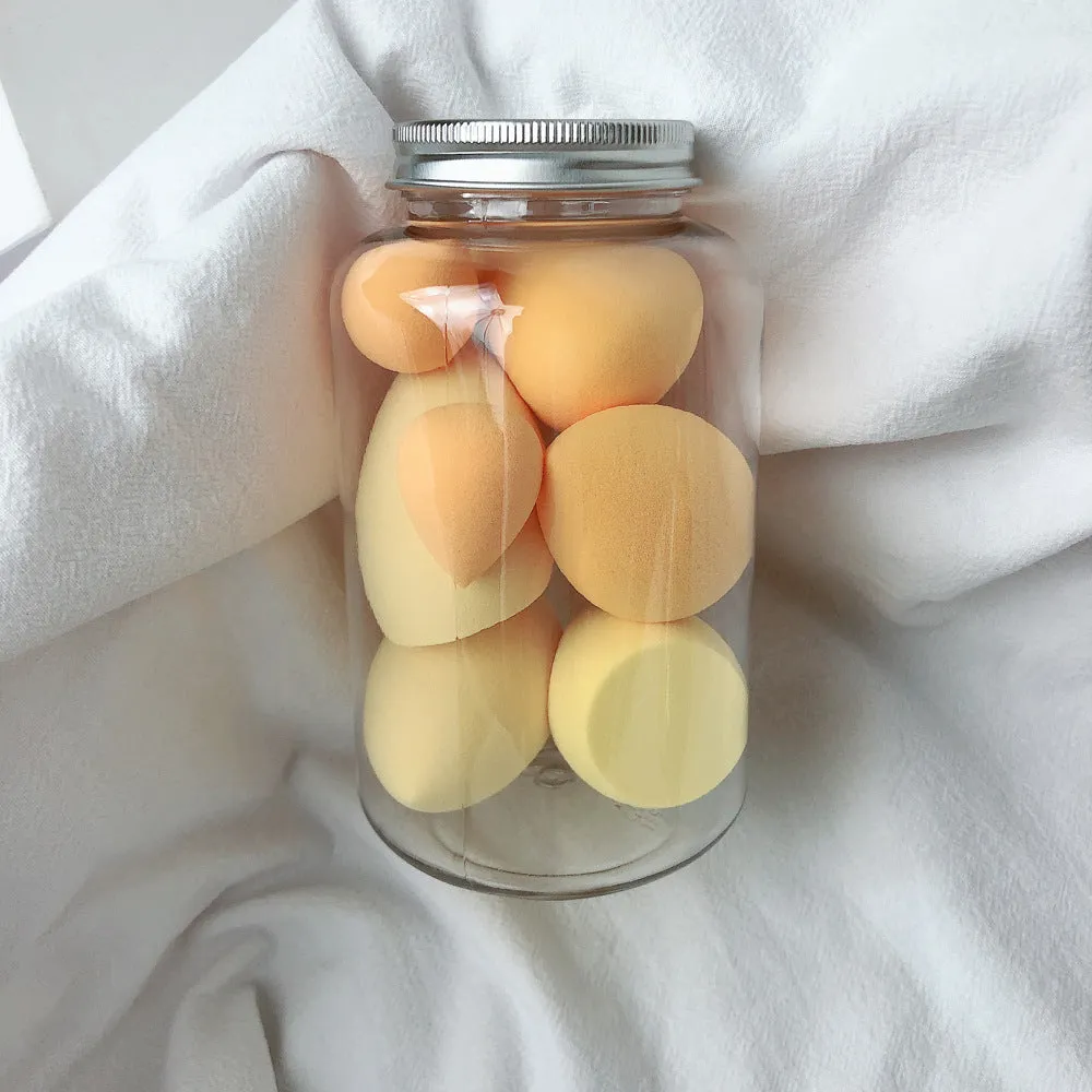 Set of 7 makeup sponge eggs in various colours inside transparent jar with multiple cut shapes