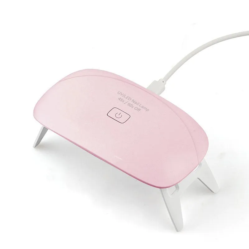 Portable nail dryer in white colour with phototherapy lamp and sealing function on a table