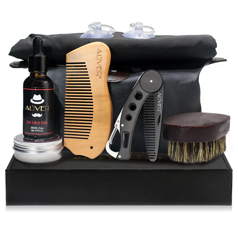 7-piece black beard grooming set with wood brush, metal comb, scissors, apron and cleaning brush on a surface