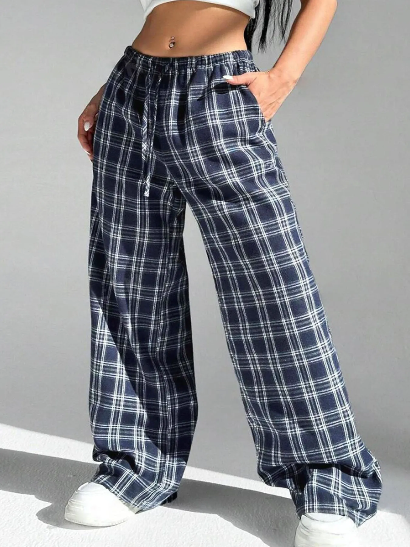 Women's blue plaid trousers with elastic drawstring waist and patch pockets laid flat