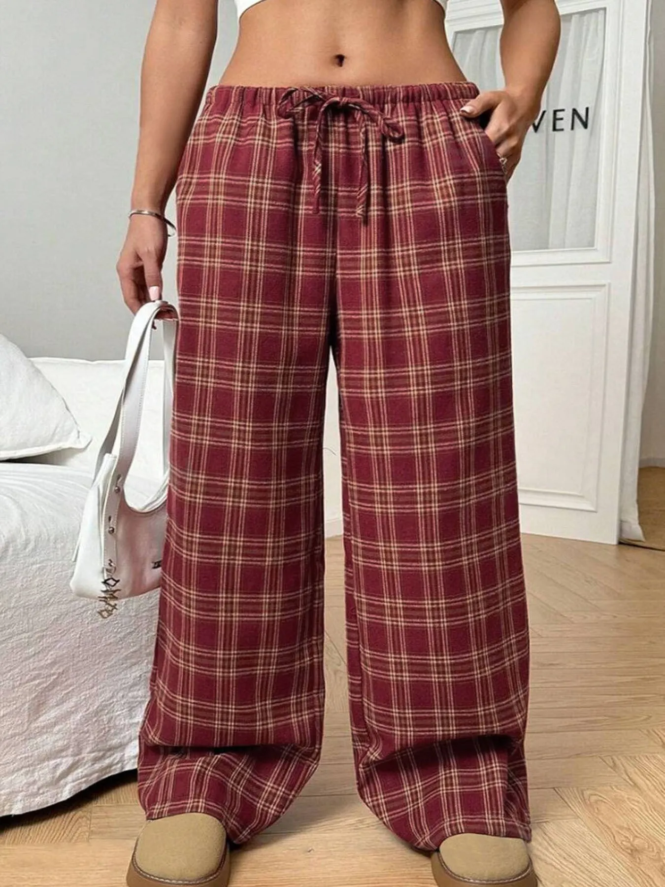Women's blue plaid trousers with elastic drawstring waist and patch pockets laid flat