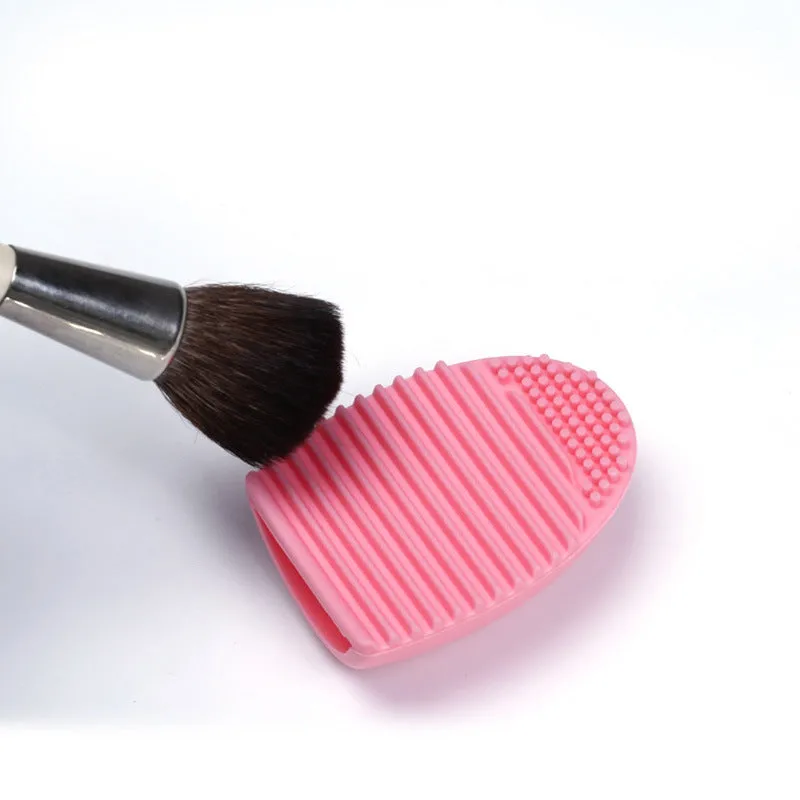 Silicone makeup brush wash egg in blue with top knobs and bottom grooves for cleaning bristles
