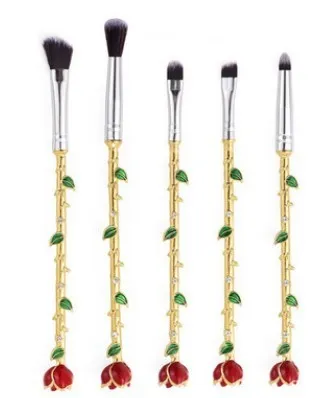 Beauty and the Beast makeup brush set with golden handles and synthetic bristles displayed on a surface