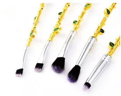 Beauty and the Beast makeup brush set with golden handles and synthetic bristles displayed on a surface