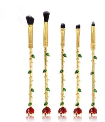 Beauty and the Beast makeup brush set with golden handles and synthetic bristles displayed on a surface