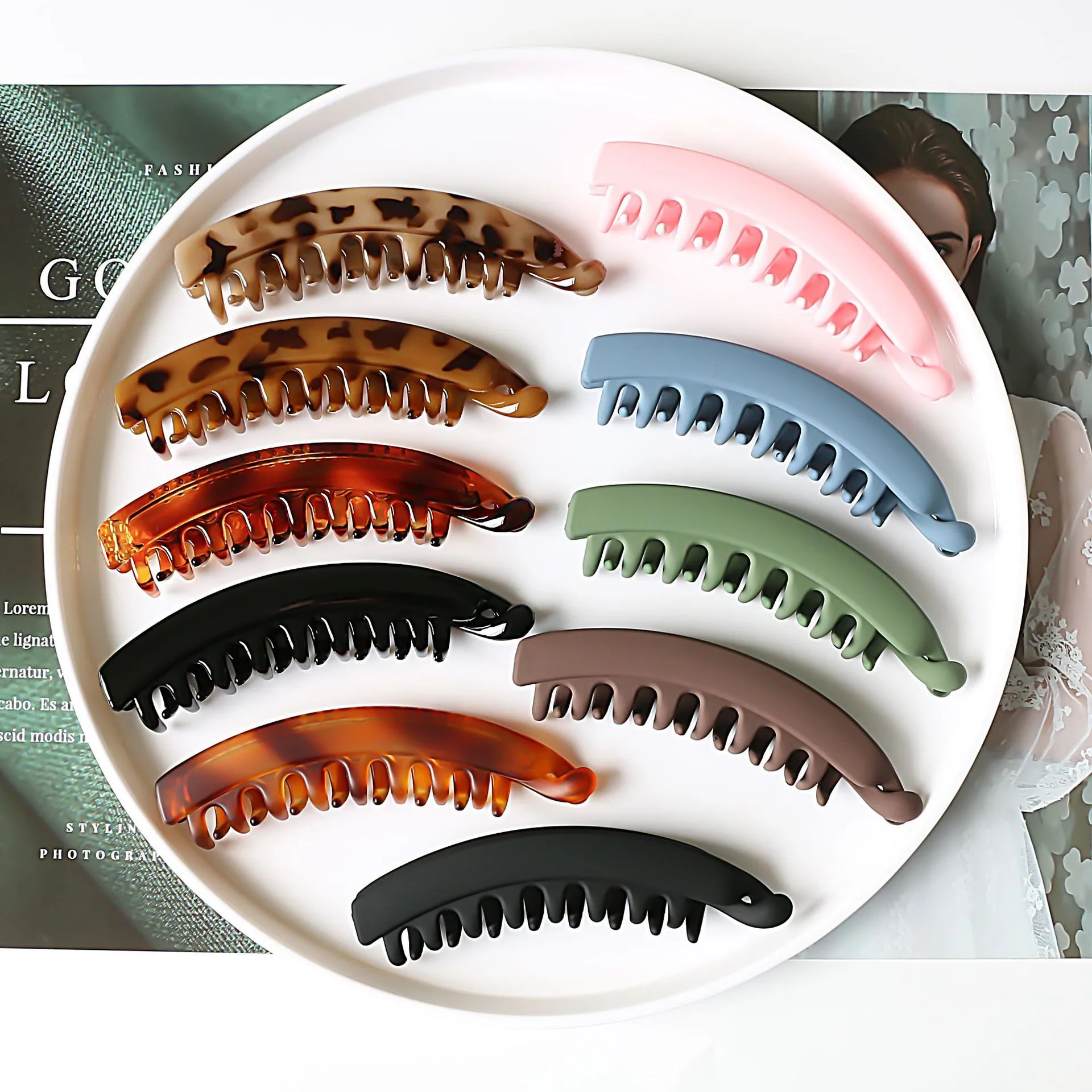 Banana hair clip claw with matte finish in black showing U-shaped design and oversized teeth