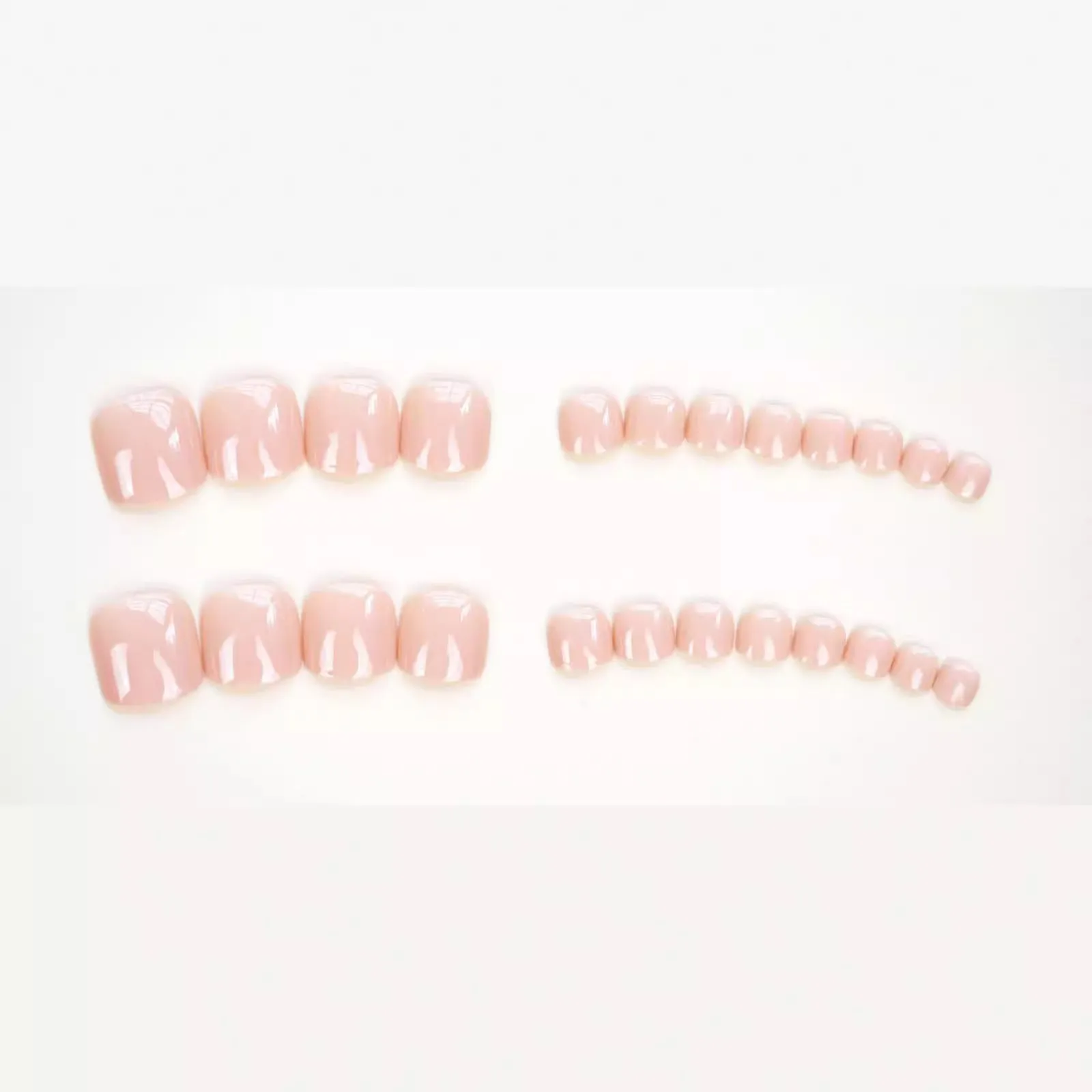 Finished plastic toe nail stickers in J-52 skin colour with glue tube on white background.