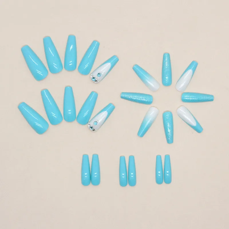 Long ballet shaped false nails in solid blue diamond colour with glitter adhesive glue.