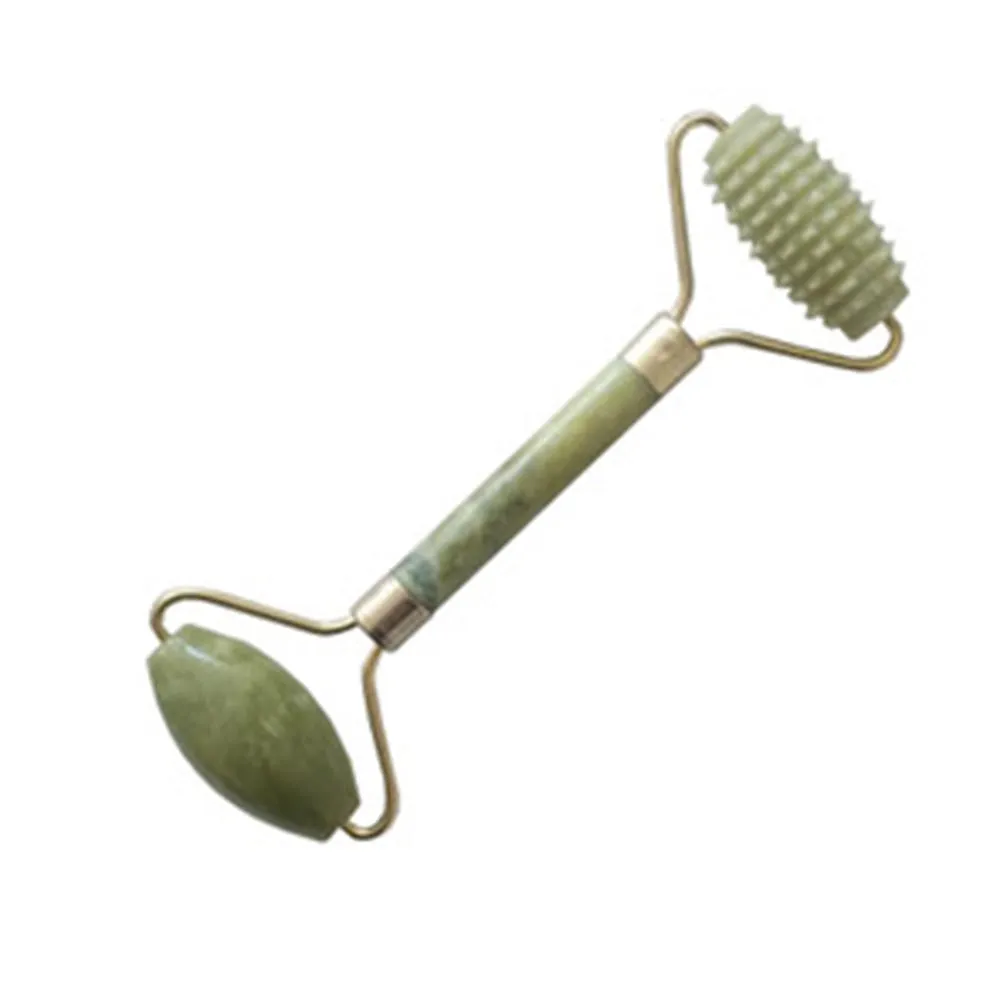 Natural green jade face massager roller and scraper set on a clean surface