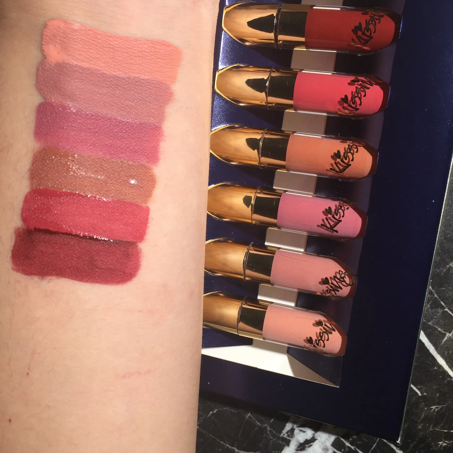 Six tubes of liquid matte lipstick in assorted shades laid out on a white background