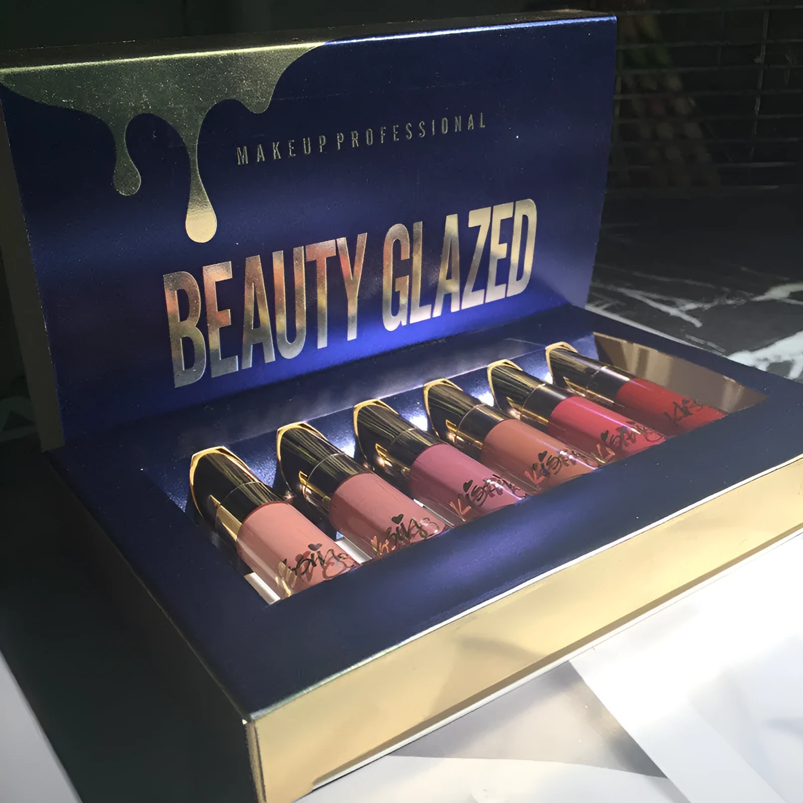 Six tubes of liquid matte lipstick in assorted shades laid out on a white background