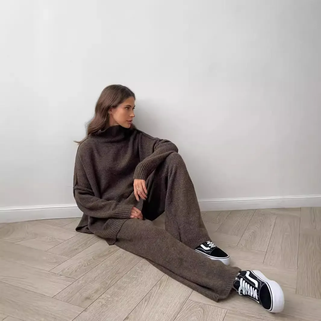 Dark grey women's knitted side-slit top and matching trousers set on a hanger