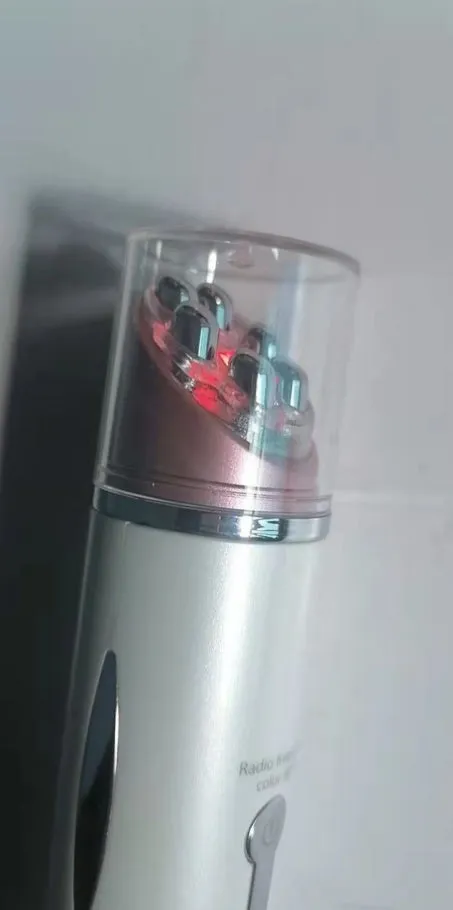 Piano white eye beauty instrument with USB cable, showing negative ion and ultrasonic wave modes