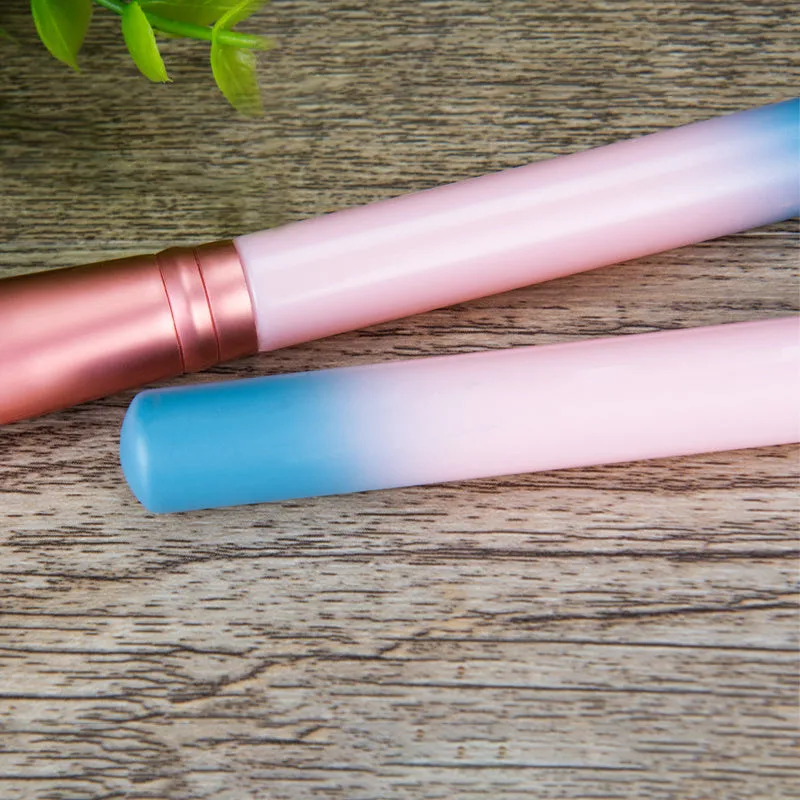 12 pink makeup brushes with synthetic hair bristles and plastic handles on a light surface