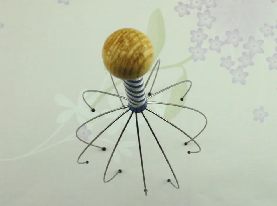 Octopus scalp massager with wooden handle and stainless steel threads on a light background