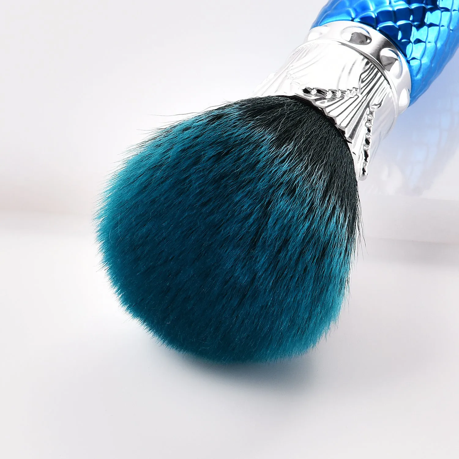 Demon blue single makeup brush with nylon bristles and plastic handle on white background